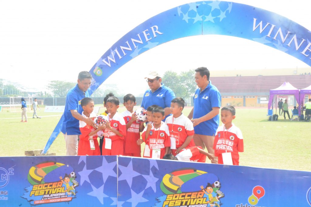 PEDULI : Secara simbolis Sutami membangikan bola pada SSB Persegrata peserta Palembang Soccer Festival 2019. FOTO : VIRALSUMSEL.COM
