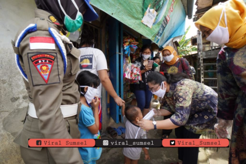 Ketua TP PKK Sumsel Feby Deru bersama Wakil Ketua 1 TP PKK Sumsel Fauziah Mawardi Yahya bagikan masker. FOTO:VIRALSUMSEL.COM