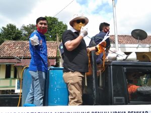 Karang Taruna Muba melakukan penyemprotan disinfektan dan pembagian masker gratis kepada masyarakat. FOTO : VIRALSUMSEL.COM