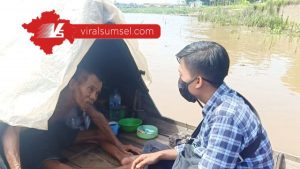 Kakek Usman manusia perahu sedang berbincang dengan wartawan www.viralsumsel.com di atas perahu miliknya. FOTO :VIRALSUMSEL.COM