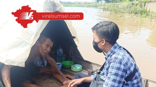 Kakek Usman manusia perahu sedang berbincang dengan wartawan www.viralsumsel.com di atas perahu miliknya. FOTO :VIRALSUMSEL.COM