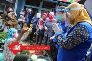 Feby Deru Ketua TP PKK Sumsel bersama Wakil Ketua TP PKK Sumsel Fauziah Mawari berikan bantuan APD pada para pedagang. FOTO : VIRALSUMSEL.COM