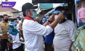 Gubernur Sumsel, H Herman Deru didampingi Ketua TP PKK Sumsel, Feby Deru membagikan 1600 APD kepada para pedagang di pasar Marga Sungsang, Banyuasin. FOTO : VIRALSUMSEL.COM