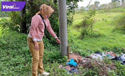 Seorang warga menunjukkan tempat ditemukannya bayi dengan ari-ari di Tempat Pembuangan Sampah. FOTO : VIRALSUMSEL.COM