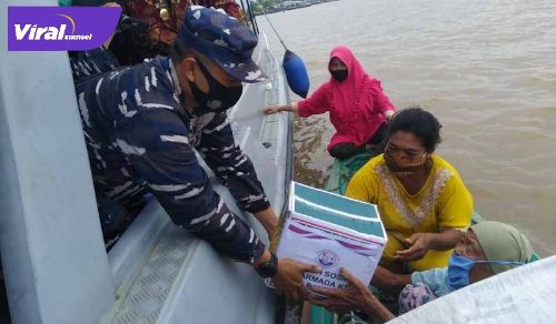 Komandan Lanal Palembang Kolonel Laut (P) Filda Malari memberikan bantuan pada warga di Pesisir Sungai Musi. FOTO : VIRALSUMSEL.COM