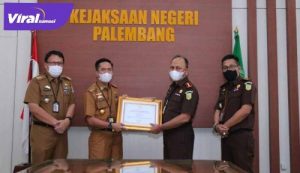 SekdaKota Palembang, Drs. Ratu Dewa, menyerahkan dua piagam penghargaan kepada Jaksa Pengacara Negara Kejari Palembang. FOTO : VIRALSUMSEL.COM