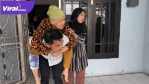 Darul Qutni Anggota DPRD Kabupaten Banyuasin gendong sang ibu yang sedang sakit. FOTO : VIRALSUMSEL.COM