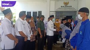 Wakil Bupati OKI, HM Dja'far Shodiq menyerahkan santuan dari Badan Amil Zakat Nasional OKI kepada ratusan petugas kebersihan pasar dan petugas kebersihan DLHK OKI di Kecamatan Kayuagung, Kamis (21/4/2022). Foto : viralsumsel.com/fir