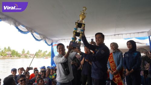 Ketua Majelis pertimbangan Karang Taruna Kabupaten OKI, M. Alki Ardhiansyah Iskandar, menyerahkan piala pada pemenang kompetisi bidar tradisional. Foto : viralsumsel.com/fir