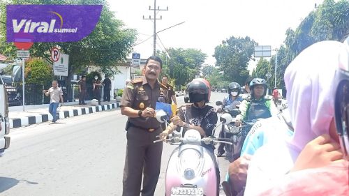 Kepala Kejaksaan Negeri OKI, Dicky Darmawan SH membagikan brosur kepada para pengendara di simpang lampu merah, Kayuagung, Kamis (29/9/2022). Foto : viralsumsel.com/fir