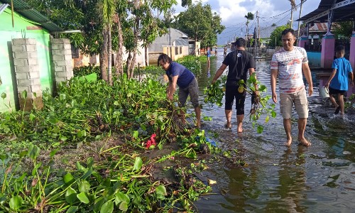 Suasana bersih-bersih rumah warga pasca banjir yang dilakukan antara DPC PJS Kab Gorontalo dengan pihak Polsek Limboto, Jumat (19/07/2024). Foto : PJS